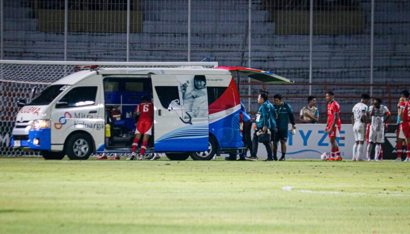 Petugas medis mengevakuasi penjaga gawang de Red FC yang mengalami cedera di tengah lapangan hijau ke ambulans.